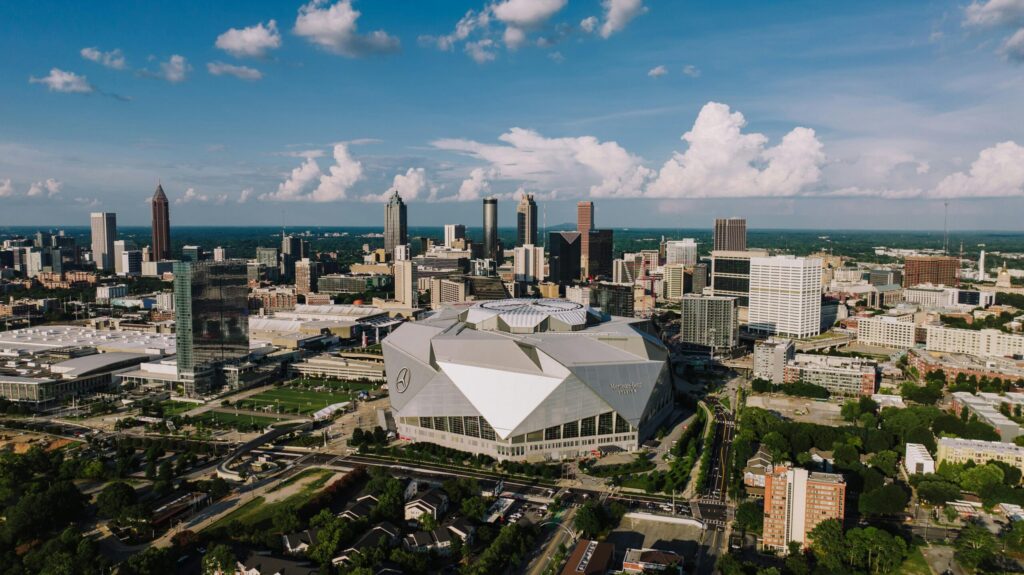 Games the NFL Needs to Flex NOW: Please, No More Dolphins on Primetime Stunning aerial view of Atlanta skyline featuring the iconic Mercedes-Benz Stadium on a clear day.